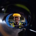 Engineer operator portrait smiling looking through steel roll